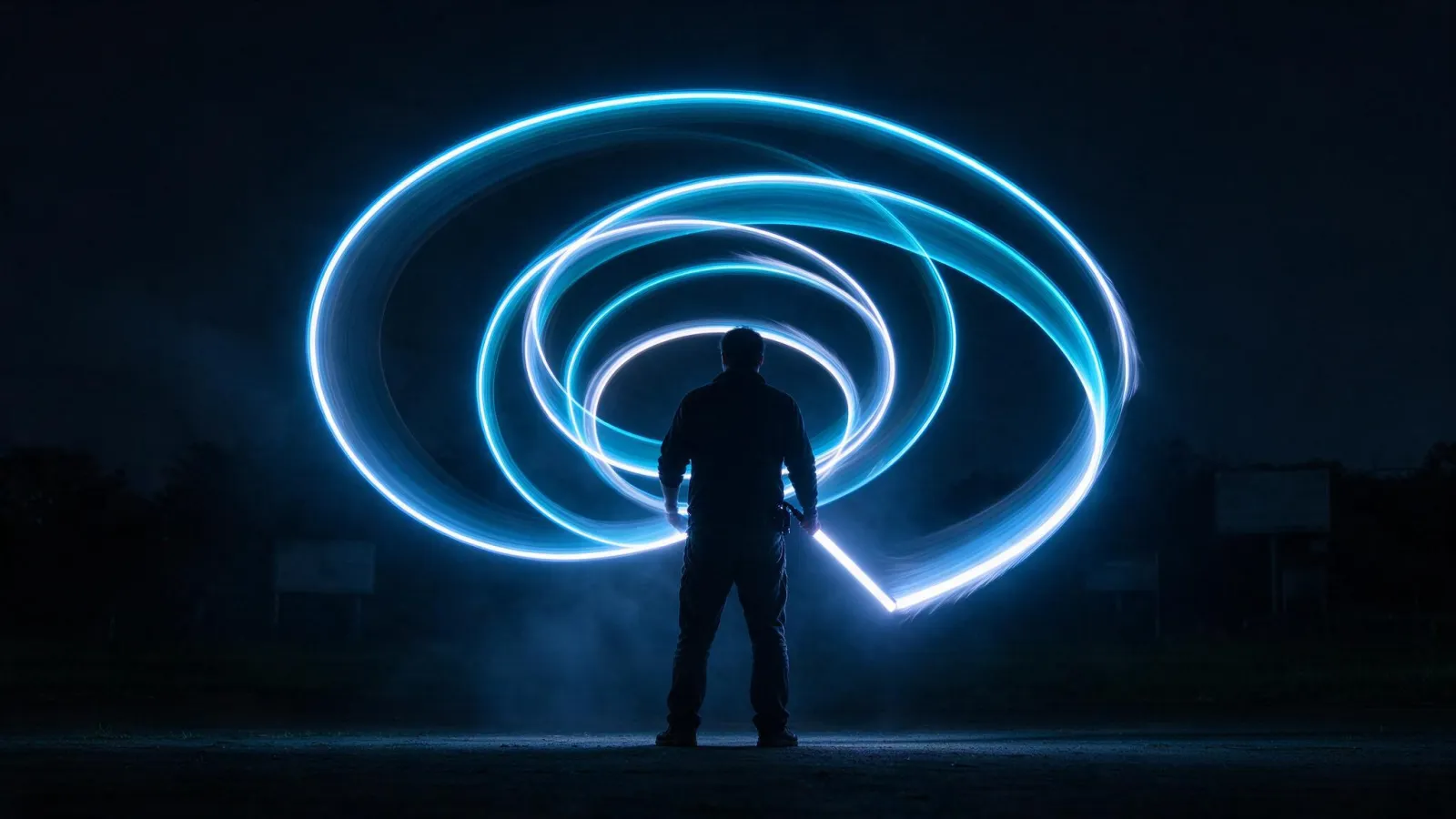 Ảnh minh hoạ Vẽ bằng ánh sáng (light painting): ảnh phơi sáng dài một người cầm que LED vẽ vòng xoắn ánh sáng trong đêm, kèm thông số chụp